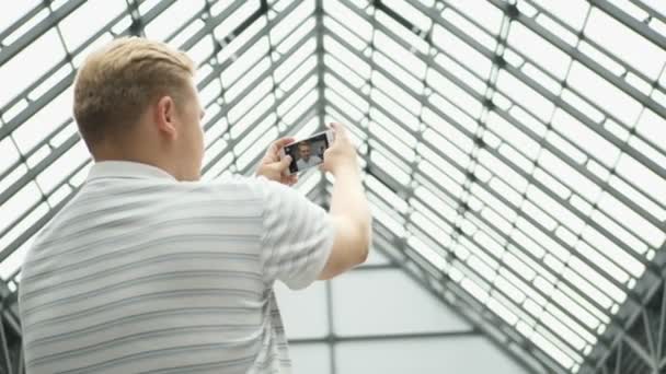 Joven hombre chats de vídeo en el teléfono inteligente. Un hombre guapo tomando una selfie. Pareja tomando autorretrato utilizando la cámara del teléfono inteligente. Citas pareja en el amor divertirse tomando foto fresca franca sonriendo — Vídeo de stock