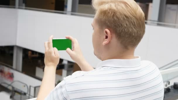 Smartphone με πράσινο οθόνη αρσενικό τα χέρια παίζοντας ένα παιχνίδι σε λειτουργία τοπίο. Εύκολη προσαρμόσιμη πράσινη οθόνη. Ο άνθρωπος βλέποντας στο κινητό τηλέφωνο ταινία πράσινη οθόνη φόντου. παίζει το παιχνίδι στο smartphone σε καφετέρια — Αρχείο Βίντεο