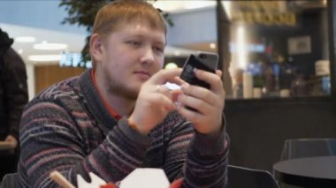 Yaşam tarzı heyecanlı smartphone evde kullanarak kredi kartıyla alışveriş online adam ve bağlı satınalma bankacılık mobil uygulama hakkında mutlu çekici adam mesaj gönderme smartphone kullanarak evde