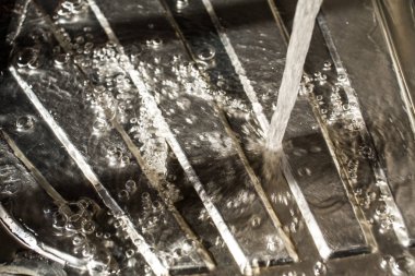 Gümüş yüzeye düşen su damlaları lavabo mutfakta