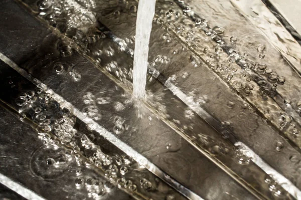 Gouttes d'eau tombant sur la surface argentée, évier dans la cuisine — Photo