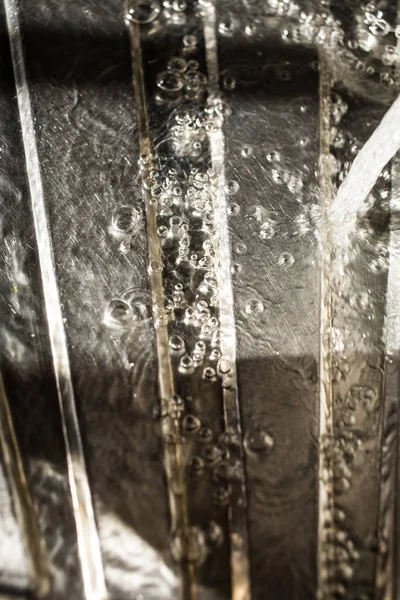 Druppels water vallen op zilver oppervlak, zinken in keuken — Stockfoto