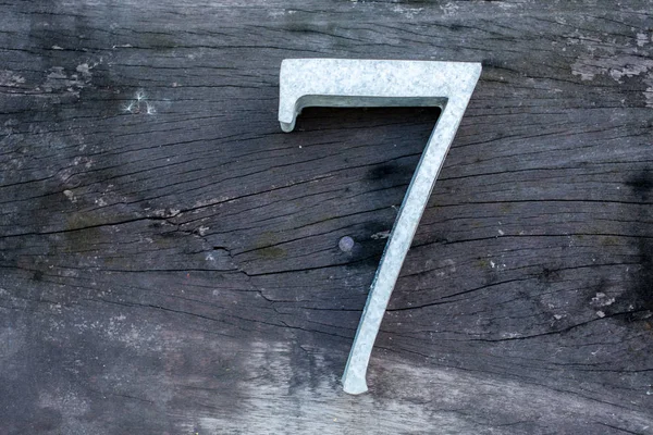 Nummer 7 (sju) tillverkad av zink på trä textur bakgrund — Stockfoto