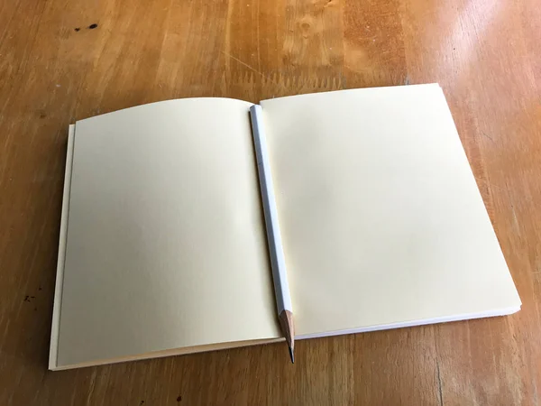 Caderno com lápis branco sobre fundo de madeira, Fechar — Fotografia de Stock