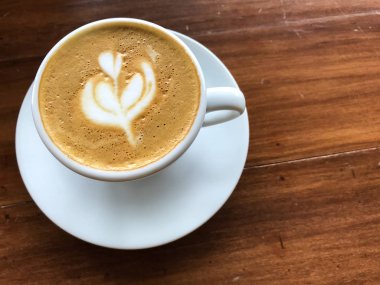 Ahşap masa arkasında bir fincan kahve.