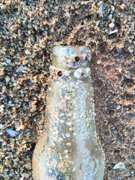 Une bouteille en verre avec grange sur la plage, Pollution de la plage — Photo
