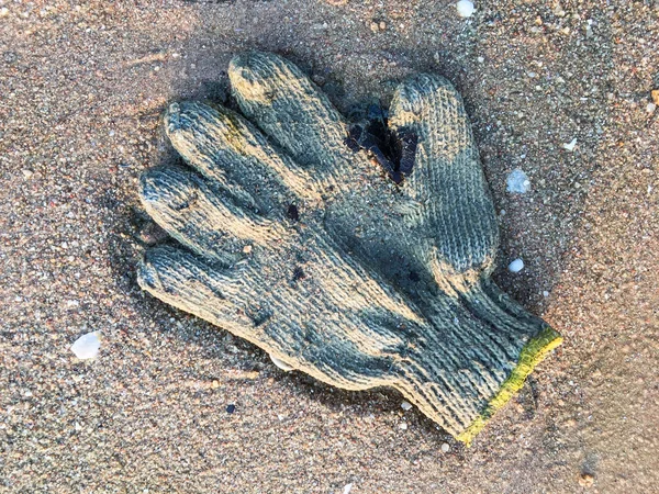 Sale gant d'hiver tricoté sur la plage — Photo