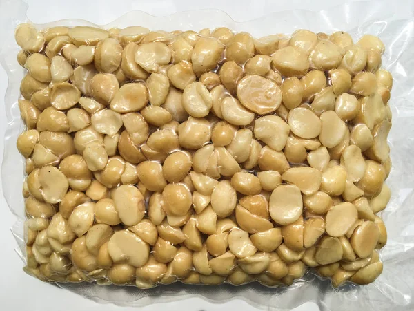 Macadamia Орех в вакуумном пластиковом пакете изолированы на белом фоне — стоковое фото