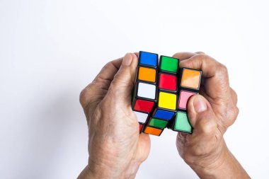 Bangkok, Tayland, beyaz arka plan, bir Macar mimar Erno Rubik tarafından 1974 yılında icat Rubik küpü üzerinde 06 Mayıs 2018, Rubik küpü tutarak ve onunla oynamak yaşlı kadın izole