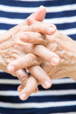 Üst düzey kadının eller eylem çizgili T gömlek arka plan üzerinde