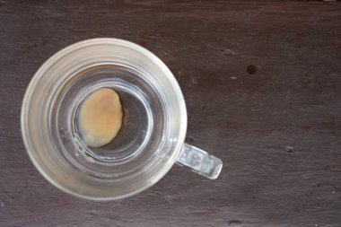 Cam kahve fincanı, ahşap masa arkasında bırakılmış kahve içeceği, yakın çekim, seçici odaklanma.