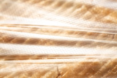 Kaw Kriab Wow made from sticky rice white plastic bag, Traditional Thai snack, Close up & Macro shot, Selective focus, Abstract texture background