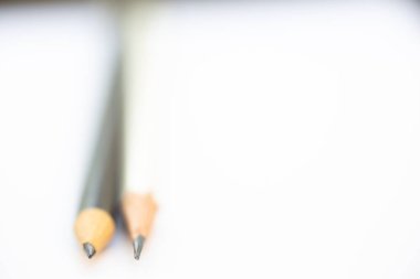 A white pencil with a black pencil on white background, Close up & Macro shot, Selective focus, Stationery concept