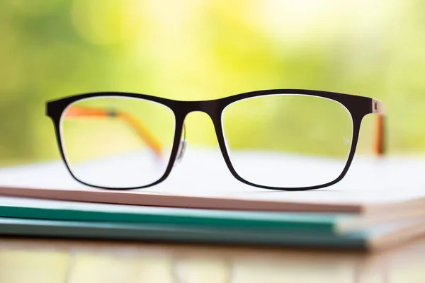 Black Eyeglasses Three White Notebook Wooden Table Bokeh Garden Background — Φωτογραφία Αρχείου