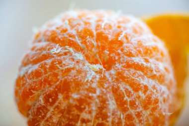 Turuncu meyve beyaz arkaplanda soyulmuş, yakın çekim, seçici odak