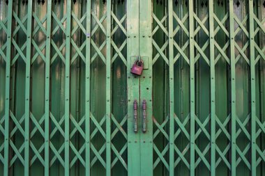 Kapalı yeşil çelik kapı, kilitli altın anahtarla esnetiliyor.