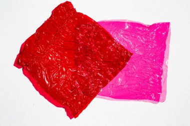 Beyaz zemin üzerinde parlak buruşuk yüzey dokusuna sahip ince renkli selofan yaprak, soyut, Aydınlık ve Gölge konsepti