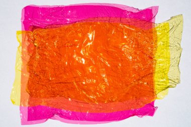 Beyaz zemin üzerinde parlak buruşuk yüzey dokusuna sahip ince renkli selofan yaprak, soyut, Aydınlık ve Gölge konsepti