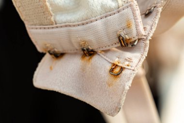 Eski sutyen yıpranmış ve yıpranmış, paslı kancalar ve paslı sutyen, bulanık arka plan, & Makro çekimini kapat, Seçici odak