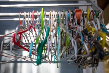 Old colorful plastic and steel  clothes hangers on clothes rack, Close up shot, Selective focus, LIght & Shadow, Laundry work concept