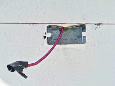 Beyaz beton arka planda kabloları olan elektrik prizleri ya da prizleri oluşturma işlemindeyken