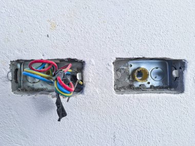 Beyaz beton arka planda kabloları olan elektrik prizleri ya da prizleri oluşturma işlemindeyken