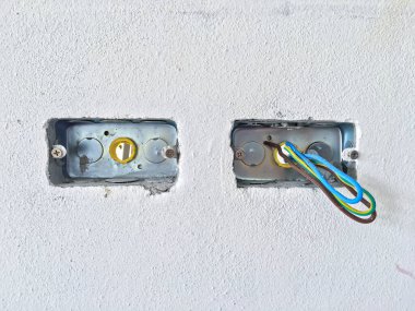 Beyaz beton arka planda kabloları olan elektrik prizleri ya da prizleri oluşturma işlemindeyken