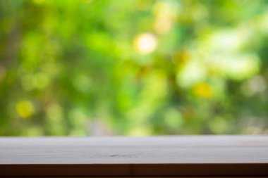 Boş ahşap masa dokusu, yeşil bahçe bulanık bokeh arka plan, seçici odak