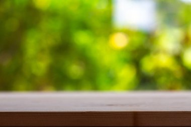 Boş ahşap masa dokusu, yeşil bahçe bulanık bokeh arka plan, seçici odak