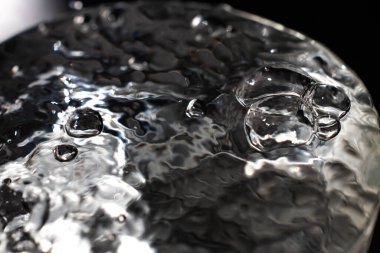 Şeffaf camda yüzen temiz su kabarcıkları, Makro çekimleri kapat, Seçici odak, Sağlıklı içecek kavramı