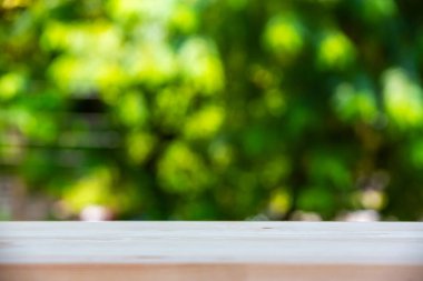 Boş ahşap masa dokusu, yeşil bahçe bulanık bokeh arka plan, seçici odak