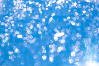 Bokeh blurred thin sheet of blue colour cellophane with shiny crumpled surface texture on white background, Abstract, Light & Shadow concept