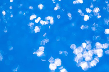 Bokeh blurred thin sheet of blue colour cellophane with shiny crumpled surface texture on white background, Abstract, Light & Shadow concept