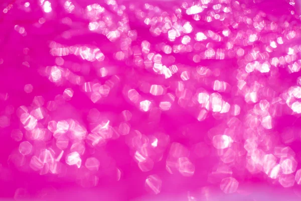Bokeh blurred thin sheet of pink colour cellophane with shiny crumpled surface texture on white background, Abstract, Light & Shadow concept