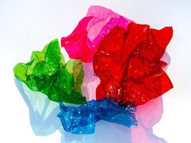 Beyaz zemin üzerinde parlak buruşuk yüzey dokusuna sahip ince renkli selofan yaprak, soyut, Aydınlık ve Gölge konsepti