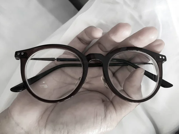 Woman Hand Holding Shortsighted Nearsighted Eyeglasses White Pillow White Bed — ストック写真