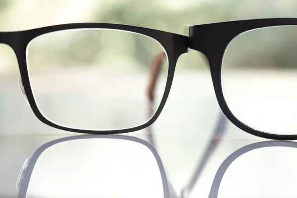 Two Black Shortsighted Nearsighted Eyeglasses White Acrylic Table Bokeh Green — 图库照片