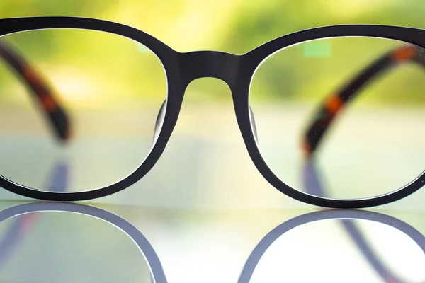 Black Shortsighted Nearsighted Eyeglasses White Acrylic Table Bokeh Green Garden — Stock fotografie