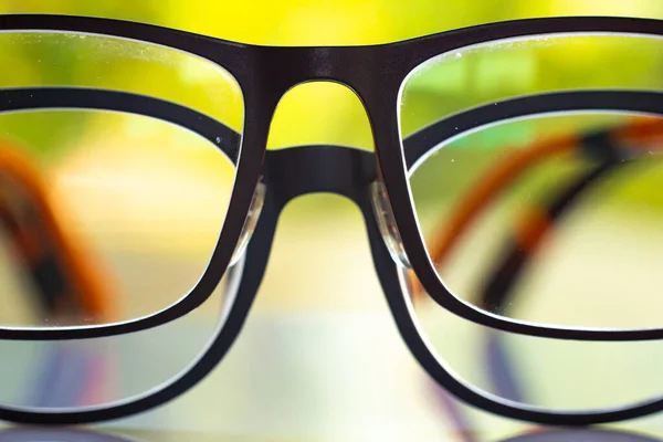 Two Black Shortsighted Nearsighted Eyeglasses White Acrylic Table Bokeh Green — Zdjęcie stockowe