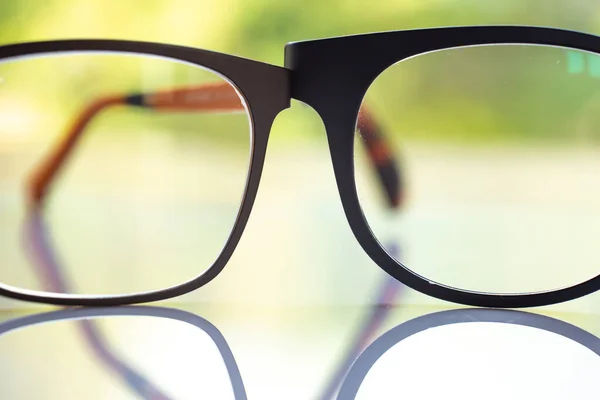 Two Black Shortsighted Nearsighted Eyeglasses White Acrylic Table Bokeh Green — Stok fotoğraf