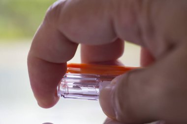 Woman's right Hand press gel ink pen or plastic ballpoint pen on white acrylic background, Close up & Macro shot, Select focus, Communication, Business, Education, Stationery concept