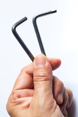 Beyaz Arkaplanda Siyah Altıgen Anahtar Anahtarı ve Metalik Hex Anahtarı kullanılarak bırakılan kadın, Yaklaş ve Makro çekim, El mekaniği araçları konsepti