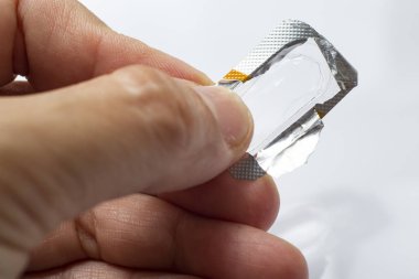 Woman's hand holding package without capsule on white background,Close up & Macro shot, Selective focus, Home concept
