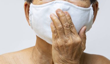 Üst düzey kadın el yapımı pamuklu bez yüz maskesi, tıbbi maske, cerrahi maske, sol el beyaz ağızlı, ön görüş, yakın çekim, Covid19 'dan korunma, Coronavirus, sağlık sigortası.