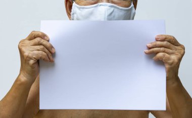 Üst düzey bir kadının elleri boş bir kağıt a4 tutarken, DIY el yapımı bezi maske, tıbbi maske, beyaz arka planda cerrahi maske, kovid19, Coronavirus, Bakteri, Sağlık Hizmetleri,