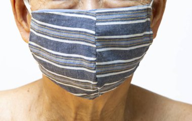 Üst düzey kadın el yapımı çizgili kumaş maske takıyor, beyaz arka planda cerrahi maske, ön görüş, yakın çekim, kovid19, Coronavirus, Bakteri, Sağlık Hizmetleri,