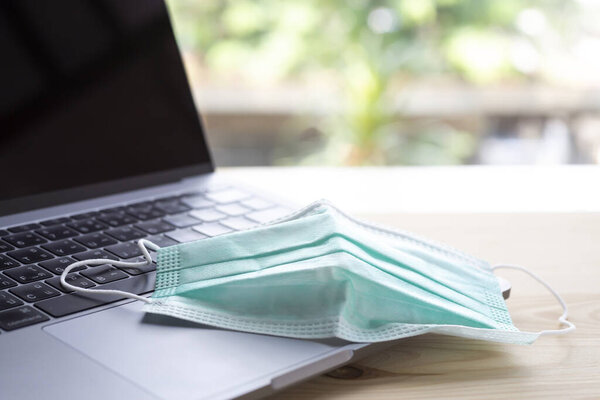 Маска для лица, Медицинская маска, Хирургическая маска на ноутбуке, Деревянный текстурный фон, Крупный план, Селективная фокусировка, Предотвращение ковид19, Коронавирус, Бактерии, Здравоохранение
