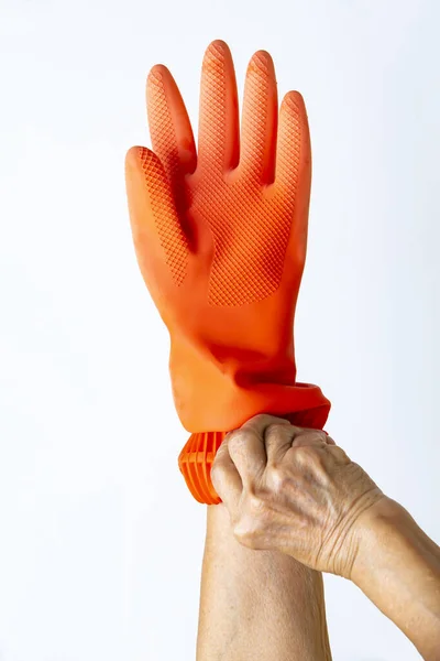 Руки Пожилой Женщины Оранжевой Резиновой Защитной Перчатке Белом Фоне Крупным — стоковое фото