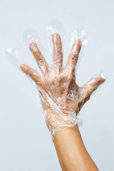 Руки Пожилой Женщины Одеты Одноразовую Защитную Пластиковую Перчатку Сером Фоне — стоковое фото