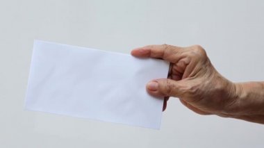 Beyaz arka planda izole edilmiş beyaz zarf ya da gelinin sağ eli, yakın çekim ve makro çekim, iş konsepti